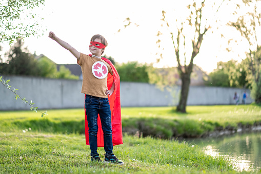 happy boy with raised hand in recycling costume