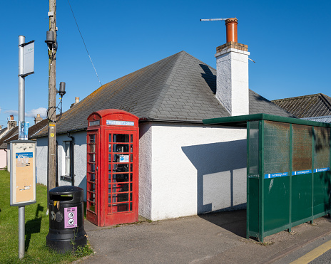 17 August 2023. Findhorn,Moray,Scotland. This is a Red old syle Telephone Box for email, text or phone along with a Bus Stop and Shelter for village transportation.
