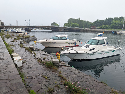 Hakodate, Japan - June 10, 2023: Boats line the promenade in Omachi by the bay. Background shows Nijima Bridge to Midori no Shima.