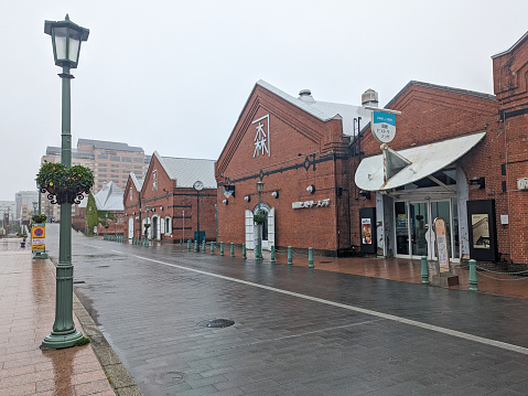 Hakodate, Japan - June 10, 2023: The Kanemori Red Brick Warehouse is a popular shopping mall in Toyokawa-cho in the Hakodate Bay Area. Rainy spring morning in the port city.