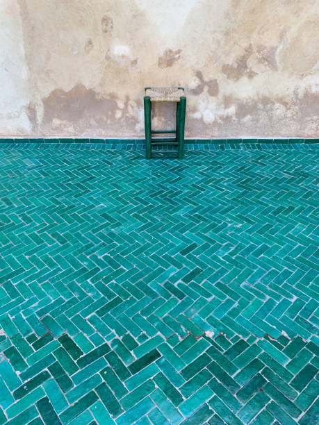 A Single Stool On Green Tile Against A Wall stock photo