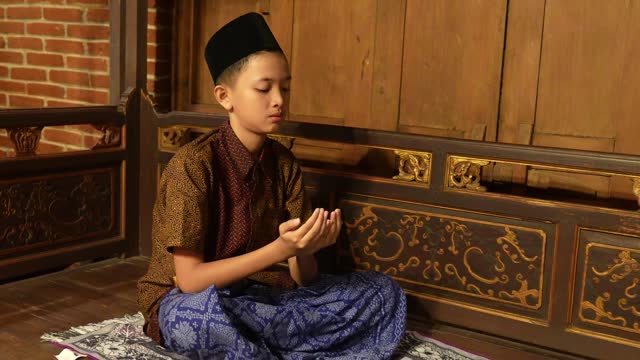 young muslim praying worship of the Allah's kindness. Muslim children are doing prayers according to Islamic principles