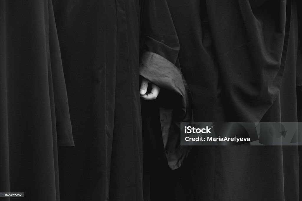 Monk's hand Monk's hand is barely seen from a long-sleeved pleated black robe Ceremonial Robe Stock Photo