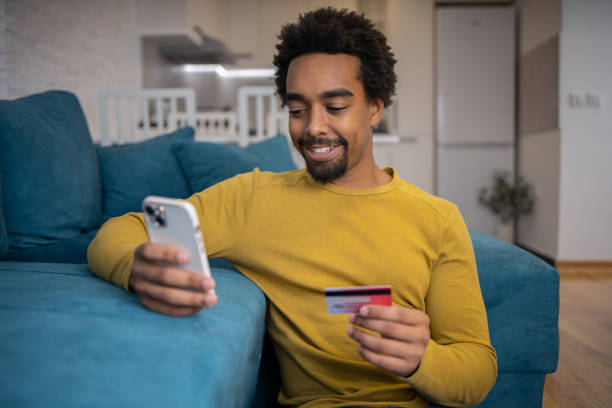 istock Cheerful man doing online shopping 1624000540