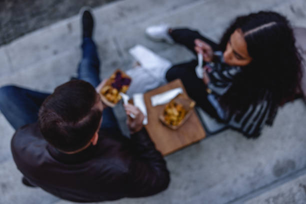 istock Multicultural Young Couple Eating A Snack On The Street 1624018586