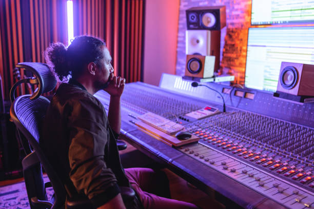 istock Black Male Sound Engineer  Looking At The Computer Screen In Front Of The Audio Mixer Console 1624019726