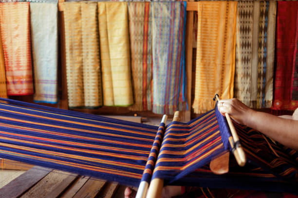 Beautiful Asian Woman Learning to Make Handmade Traditional Woven Tenun Cloth stock photo