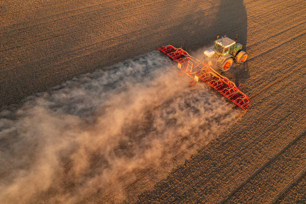 istock Tractor kicking up dust in field, aerial view 1624028631