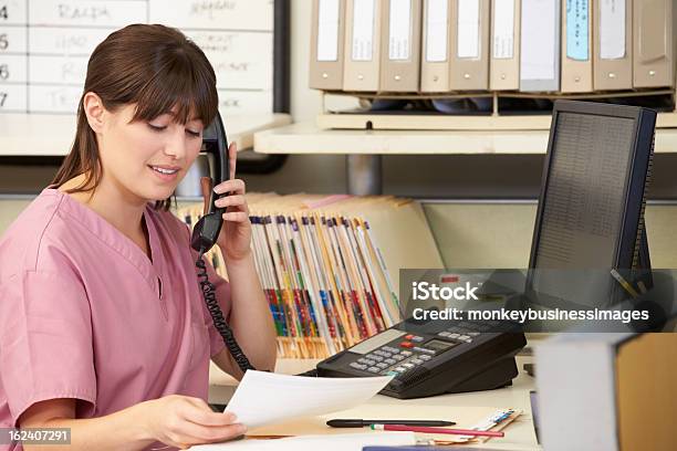 Infermiera Facendo Telefonate A Gabbiotto Delle Infermiere - Fotografie stock e altre immagini di Receptionist