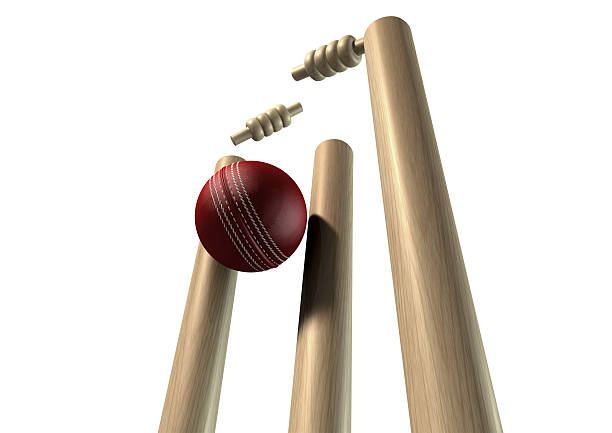 Cricket Ball Hitting Wickets Perspective Isolated A red leather cricket ball striking and unsettling wooden cricket wickets and bails on an isolated background cricket stump photos stock pictures, royalty-free photos & images