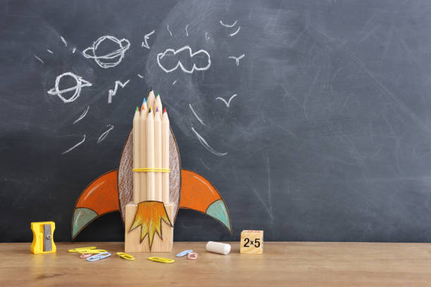 istock Back to school concept. rocket and pencils over classroom blackboard. Top view 1624095908