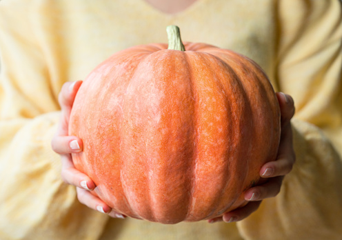 Woman holding a pumpkin.
