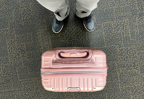 Top view plastic case and blackshoe  Plastic impact-resistant suitcase for transporting  Case  Plastic box lid top view. Transport box on ground  traveler wheeling his big and heavy luggage