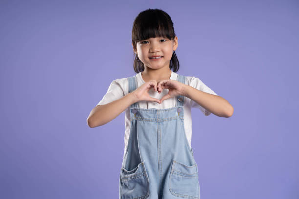 istock cute asian girl posing on purple background 1624183022