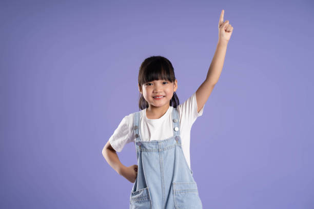 istock cute asian girl posing on purple background 1624183544