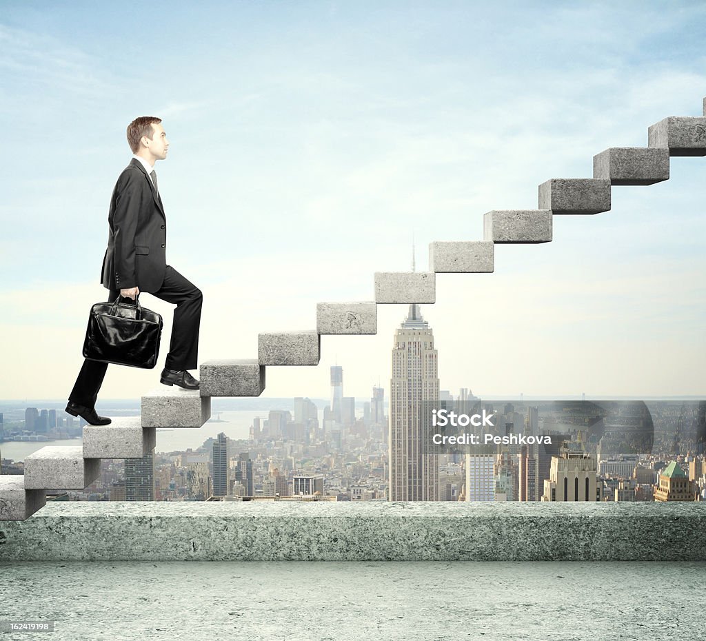 A businessman walking on a staircase Businessman stepping up a staircase and city Achievement Stock Photo