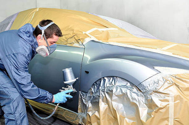 istock Car prepped and worker spraying paint on automobile 162419254