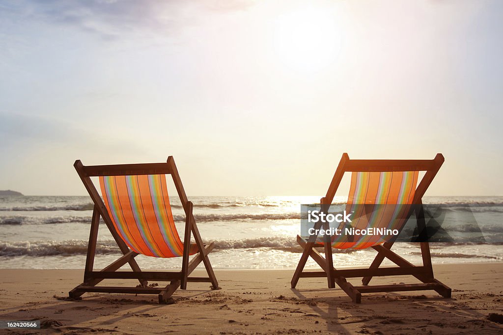 Beach Two deckchairs on the beach with bright sun and waves Vacations Stock Photo