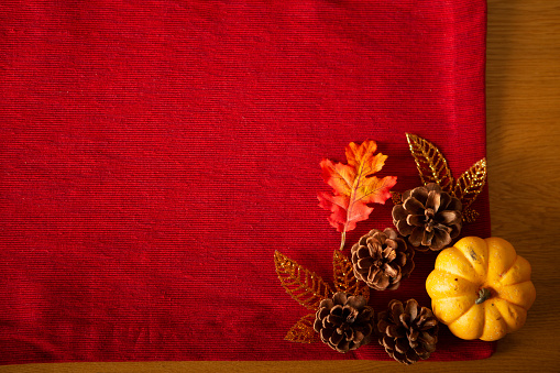 Empty red placemat with pumpkins and candles on table