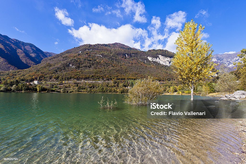 Lake Tenno, Italy Formed around the year 1100, following a huge landslide, Lake Tenno is a small body of water in the south west of Trentino, which can be reached only by foot, down a long stone stairway. You can make a complete tour of the lake, along a beautiful trail in the woods. Trentino Alto Adige, Italy.  Autumn Stock Photo