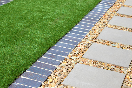 Modern backyard details combining artificial grass, gravel and paving slabs