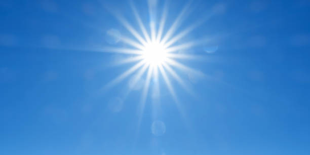 istock Panoramic sky background with radiant sun beams on bright blue sky 1624265919