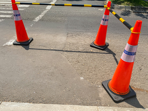 three traffic cones with black and yellow metal interconnecting