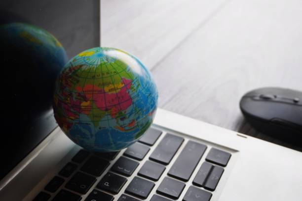 istock Close up image of globe, laptop keyboard and computer mouse. 1624412255
