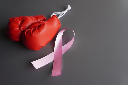 Close up image of boxing gloves and pink ribbon. Breast cancer awareness, cancer survivor concept