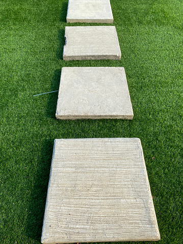 Paved tiled path on synthetic turf