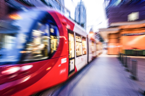 Red light rail train in close up, image in zoom-blur effect for background, urban rail transit characterized by a combination of tram.