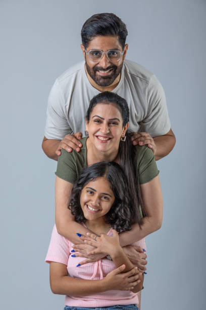 istock Smiling parents with daughter posing on white background 1624461008