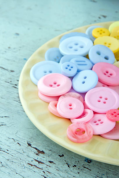 istock Pink and blue buttons on a light yellow plate 162446775