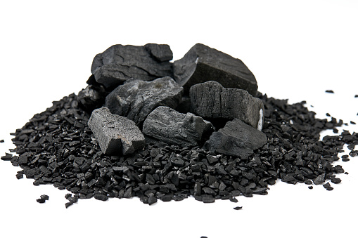 Pile of natural activated carbon scattered isolated on white background. activated carbon is used for effective applications in adsorption, removal of pollutants, water treatment, and energy, etc.
