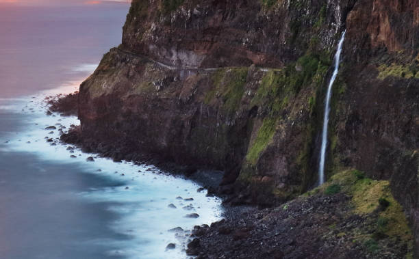 istock Madeira island - Dramatic sunrise over atlantic ocean with waterfall landscape from Miradouro do Veu da Noiva 1624496683