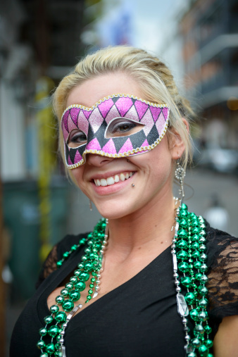A woman with mask and beads on Bourbon Street during Mardi Gras in New Orleans, LA (2013)