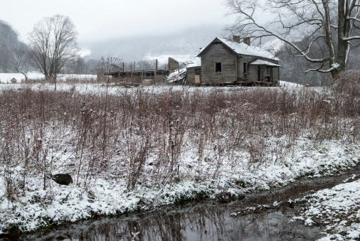 Creek and old dilapidated home on a snowy winter day in Appalachia