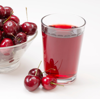 Glass of cherry juice and whole cherries