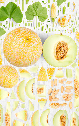 Abstract background made of Sugar Melon fruit pieces, slices and leaves on wooden background.