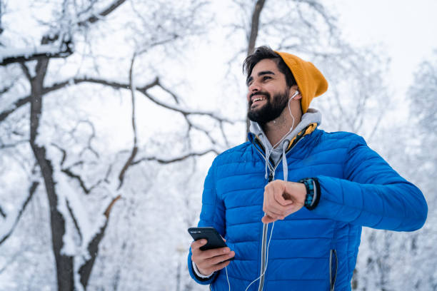 istock Happy Caucasian young man checking time on smartwatch while taking morning exercise in park 1624592949