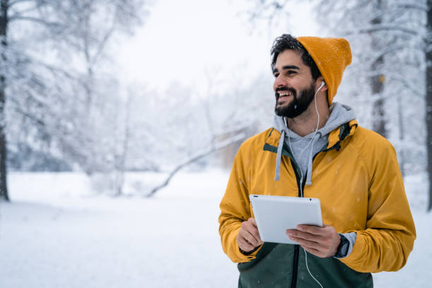istock Cheerful young man standing outside holding digital tablet 1624594599