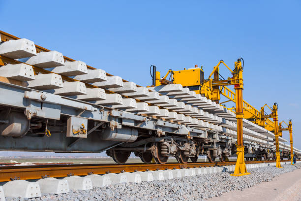 Railway or railroad construction site, railroad track installation machine is in use - Perspective view of Concrete railroad ties in railway construction site