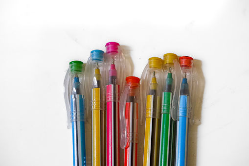 Some ballpoint pens that have various colors and a white background.