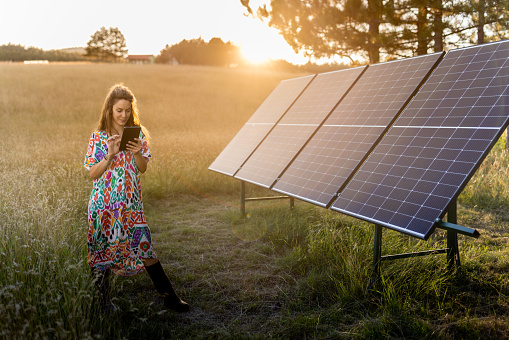 A young farmer woman checking an operations of solar panel systems