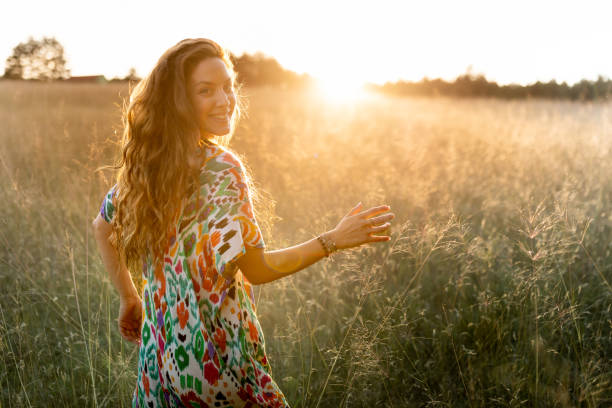 istock Happy young woman in a field at sunset looking back 1624680245