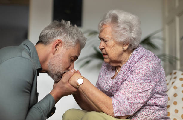 portret dojrzałego mężczyzny całującego ręce matki. - arthritis senior adult rheumatoid arthritis sadness zdjęcia i obrazy z banku zdjęć