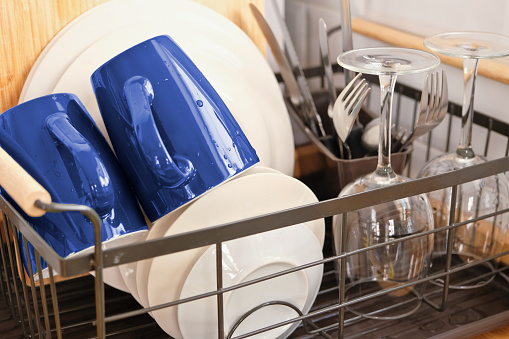 Freshly washed dishes are placed in a basket to dry.