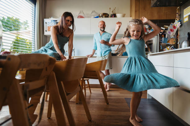 istock Little girl dancing in the kitchen, while parents watching her. 1624699579