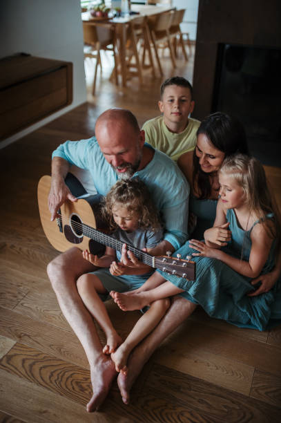 istock Father playing on guitar for his family. 1624703358