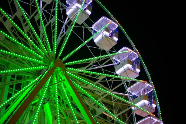 istock a large ferris wheel at night with green lights and bright blue lights 1624726413